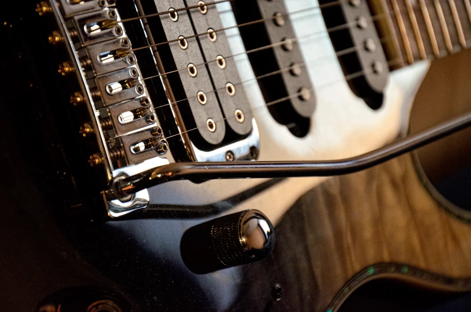 Close-up of an electric guitar's pickups, bridge and strings