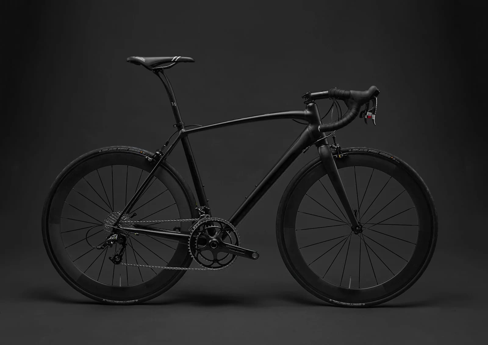 Black road bicycle photographed side-on in a studio
